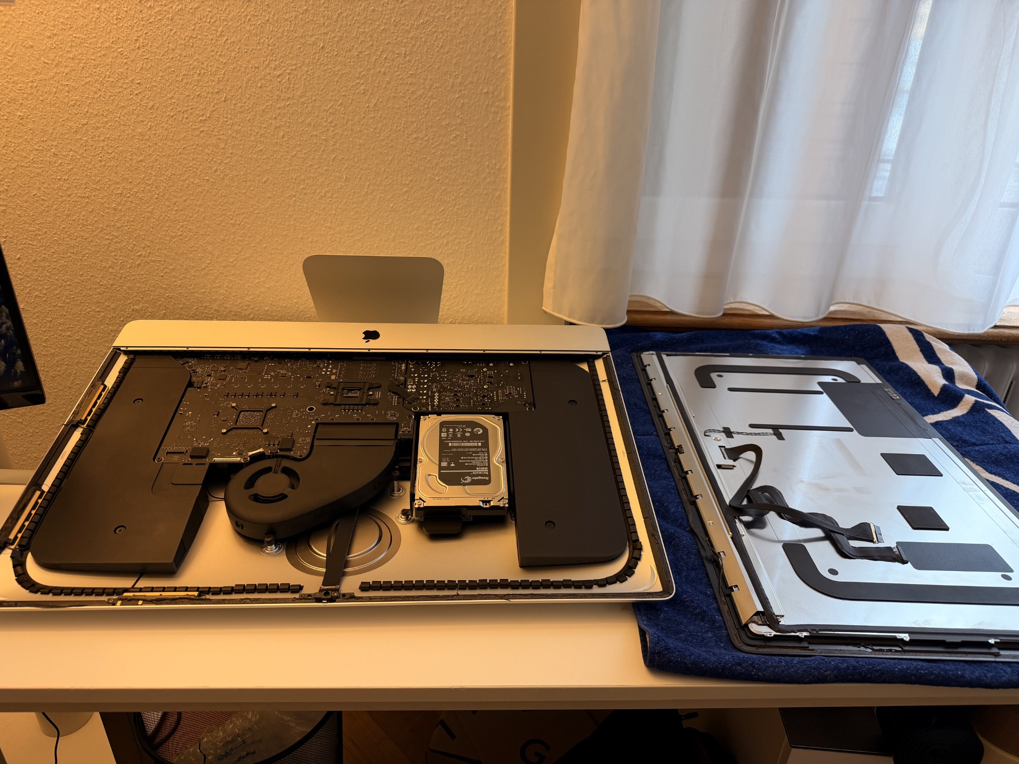 Geöffneter iMac mit alter Elektronik und daneben abgelegtem Display.