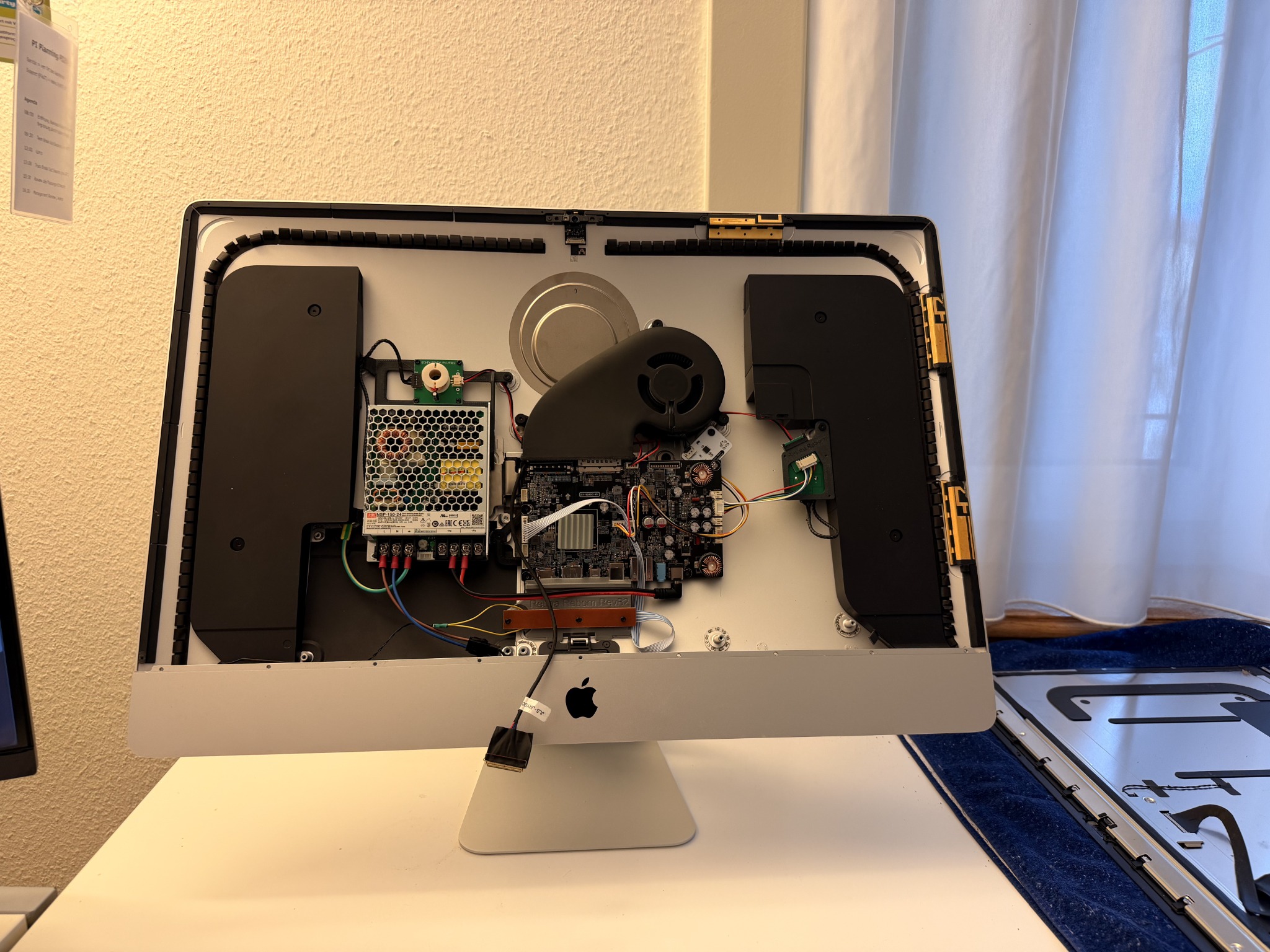 Geöffneter iMac mit eingebauter Elektronik, Netzteil, Lautsprechern und Lüfter.